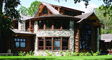 Unique round stone home with timber log accents | Log & Hybrid Homes